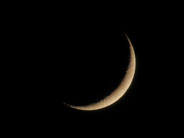 Luna în fază de seceră pe cer nocturn, simbol al ciclurilor lunare și al noilor începuturi